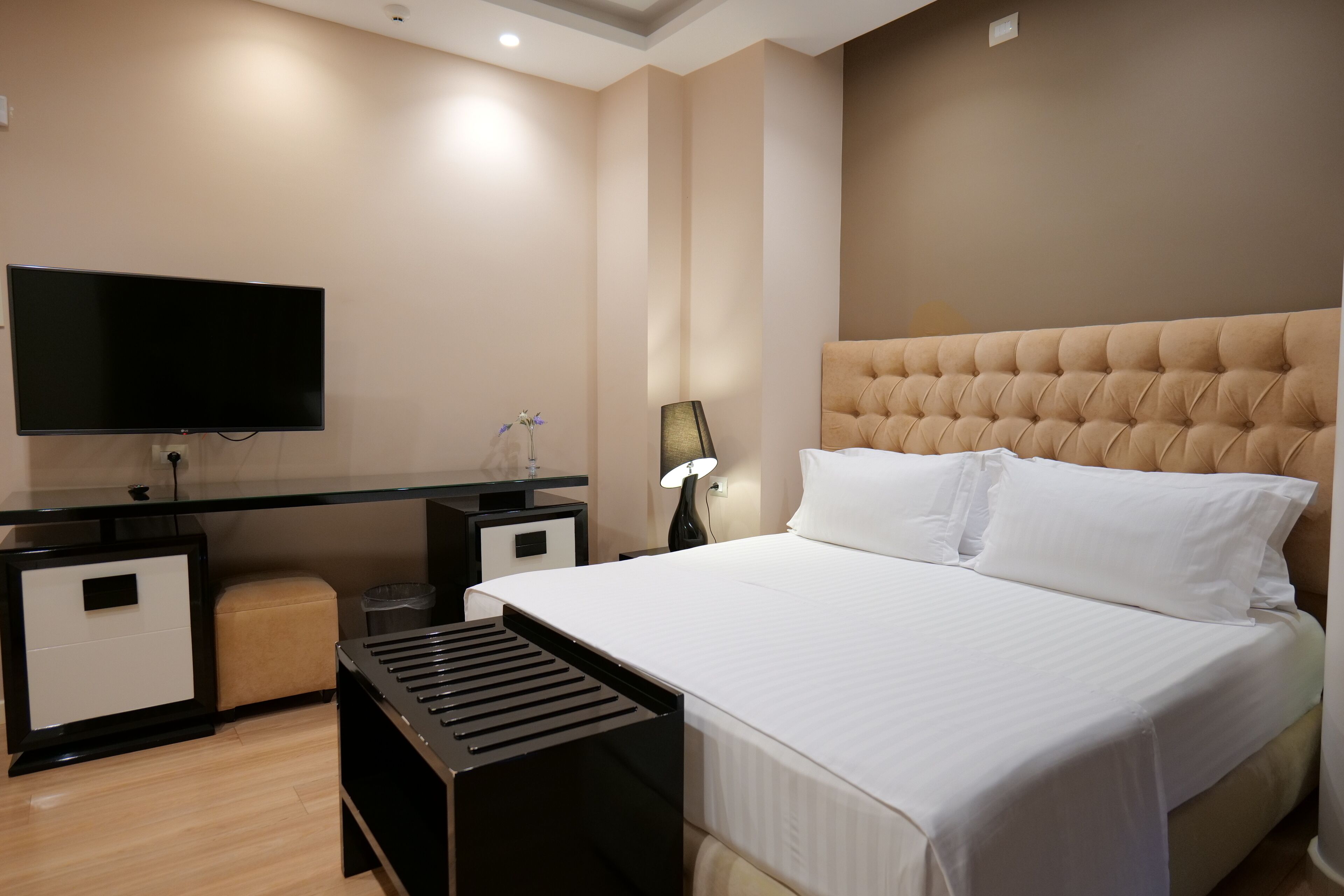 Una habitación de hotel con cama, televisión, escritorio y lámpara.