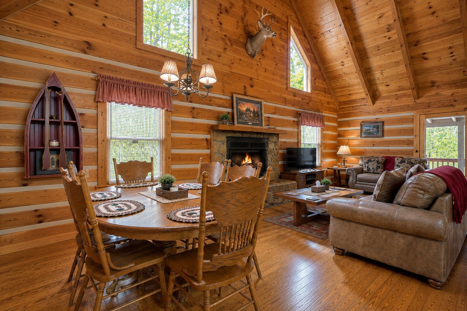 A log cabin interior with a fireplace, dining area, and living room.