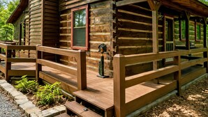 A log cabin with a porch and a chimney.