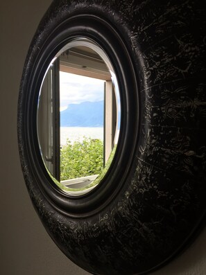 A window with a view of a body of water and mountains.