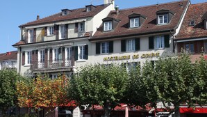 Un edificio con un letrero que dice "Hostellerie de Genève", indicando que es un hotel.