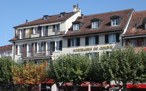 A building with a sign reading "Hostellerie de Genève" indicating it is a hotel.