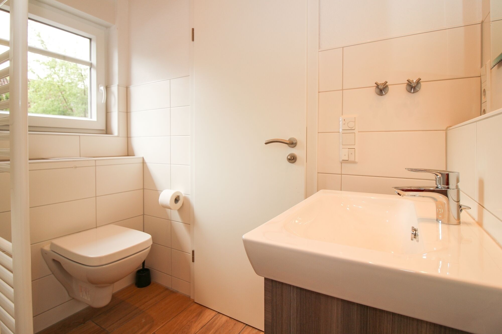 Ein Badezimmer mit Toilette, Waschbecken und Fenster.