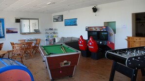 Sala de recreación con mesa de billar, mesa de fútbol de mesa y mesa de ping pong.