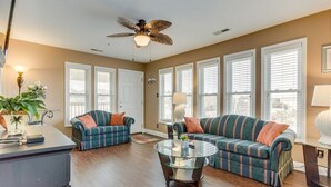 A spacious living room with a large sectional sofa, a coffee table, and a ceiling fan. - Quiet 2 bd 2 bath winter/summer getaway, steps to beach. fully furnished. (North myrtal beach)