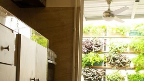 A kitchen with a built-in oven, a microwave, and a ceiling fan.