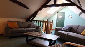 Ein gemütliches Loftsesselzimmer mit zwei Sofas, einem Holztisch und einer Bank.