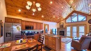 A spacious kitchen with wooden cabinets, a central island, and a dining area with a wooden table and chairs. - 2 BD 2 BA Cottage, Paved Access, Close to Town, Super Views, Cable, WIFI, (Waynesville)