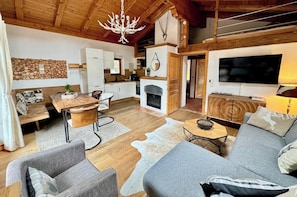 A cozy living room with a fireplace, a dining area, and a TV.