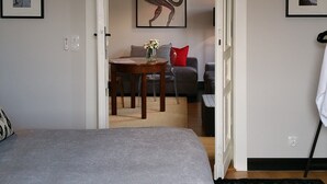 Une chambre à coucher avec un lit, une table à manger avec des chaises, un canapé et un tableau accroché au mur.