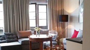 Un salon moderne comprenant un canapé, une table à manger et un coin cuisine.