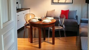 Un salon moderne avec une table à manger, un canapé et des œuvres d’art accrochées au mur.