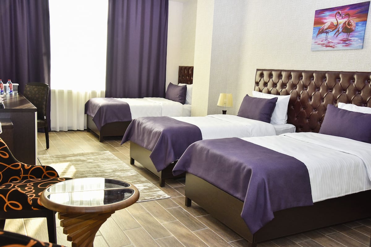 Une chambre d’hôtel avec deux lits, un bureau et une chaise.