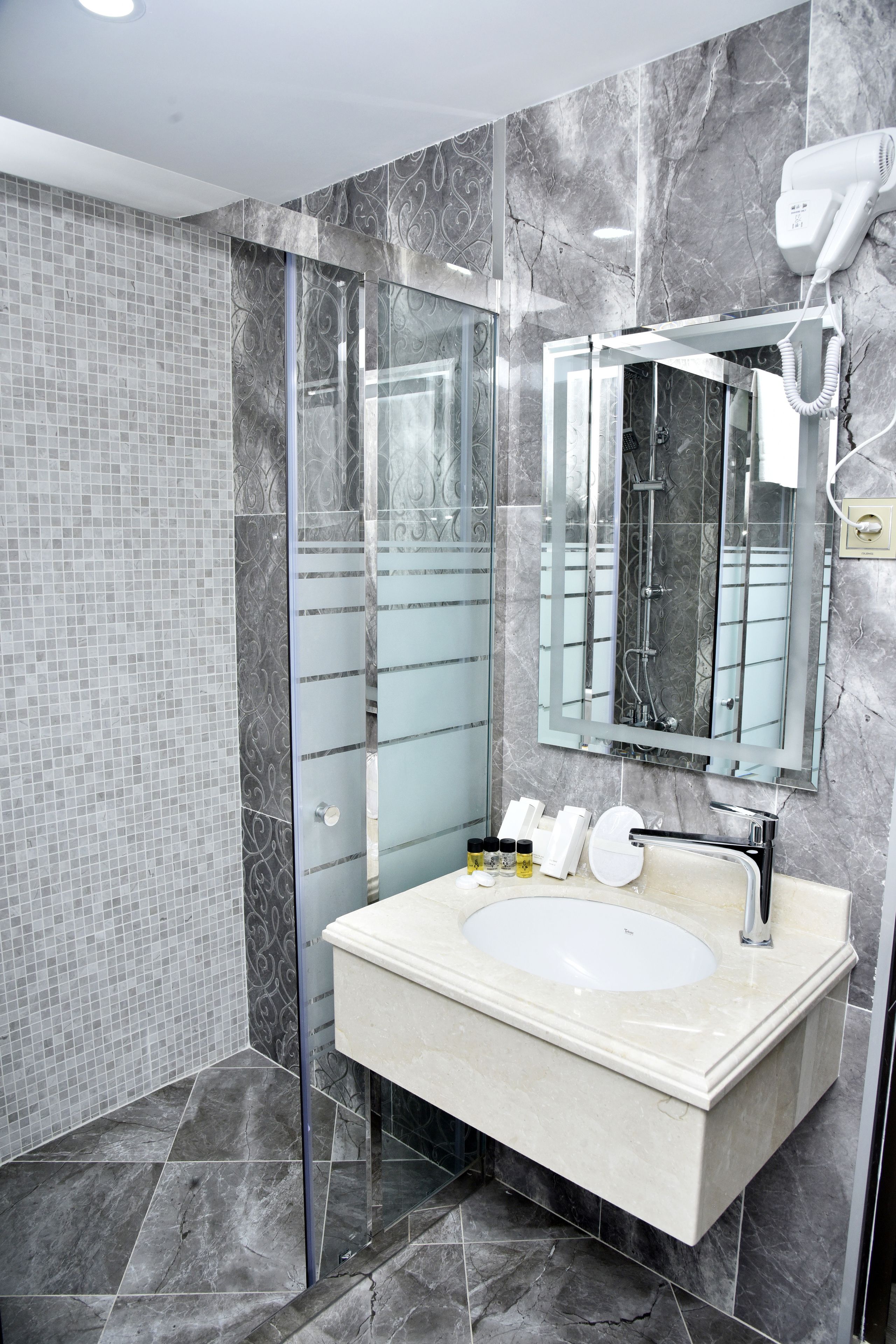 junior suite | bathroom | shower, hair dryer, slippers, towels