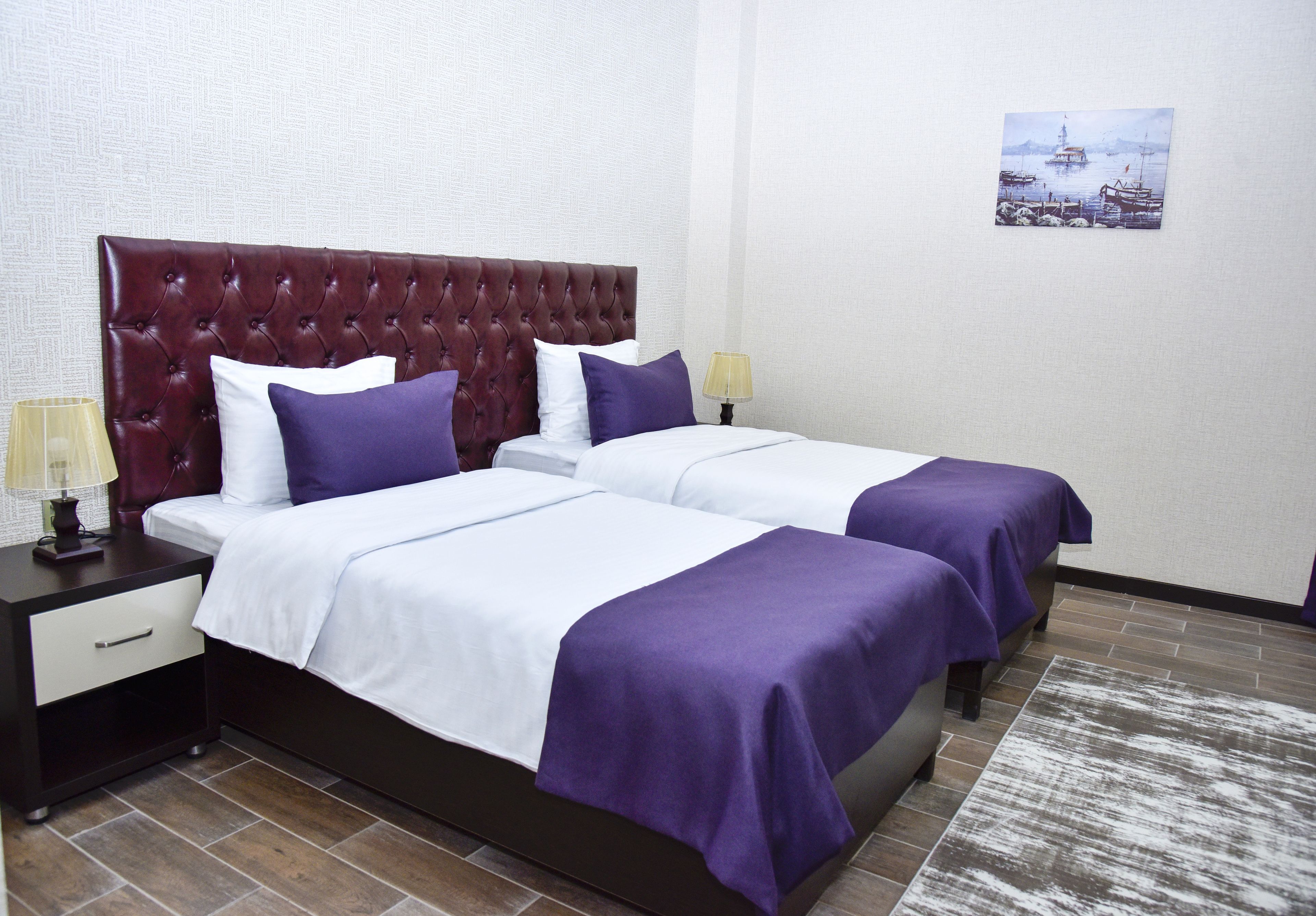 A hotel room with a large bed, two bedside tables, and a nightstand.