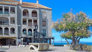 A stone building with multiple balconies and a restaurant named "Des del 1982" in front. - Lovely apartment for 6 people with WIFI and TV (L'escala)