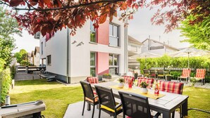 A patio area with a dining table, chairs, and outdoor seating. - "Silber-Mops" 5***** Designer Apartment for Connoisseurs ♥ Garden Access ♥ Parking Space (Bensheim)