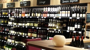 A wine store with shelves stocked with various wine bottles, price tags, and signs indicating different wine types. - "Silber-Mops" 5***** Designer Apartment for Connoisseurs ♥ Garden Access ♥ Parking Space (Bensheim)