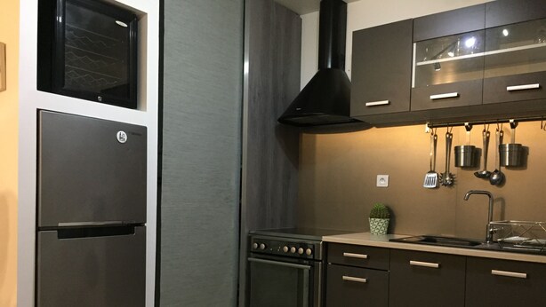 Eine moderne Küche mit Edelstahlgeräten, dunklen Schränken und einer Spritzschutzwand.