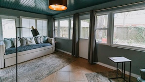 A room with a built-in bench, large windows, a ceiling light, and a small table. - Walk to the BEACH and close to DOWNTOWN - the perfect location! The Main Suite (Ocean Springs)