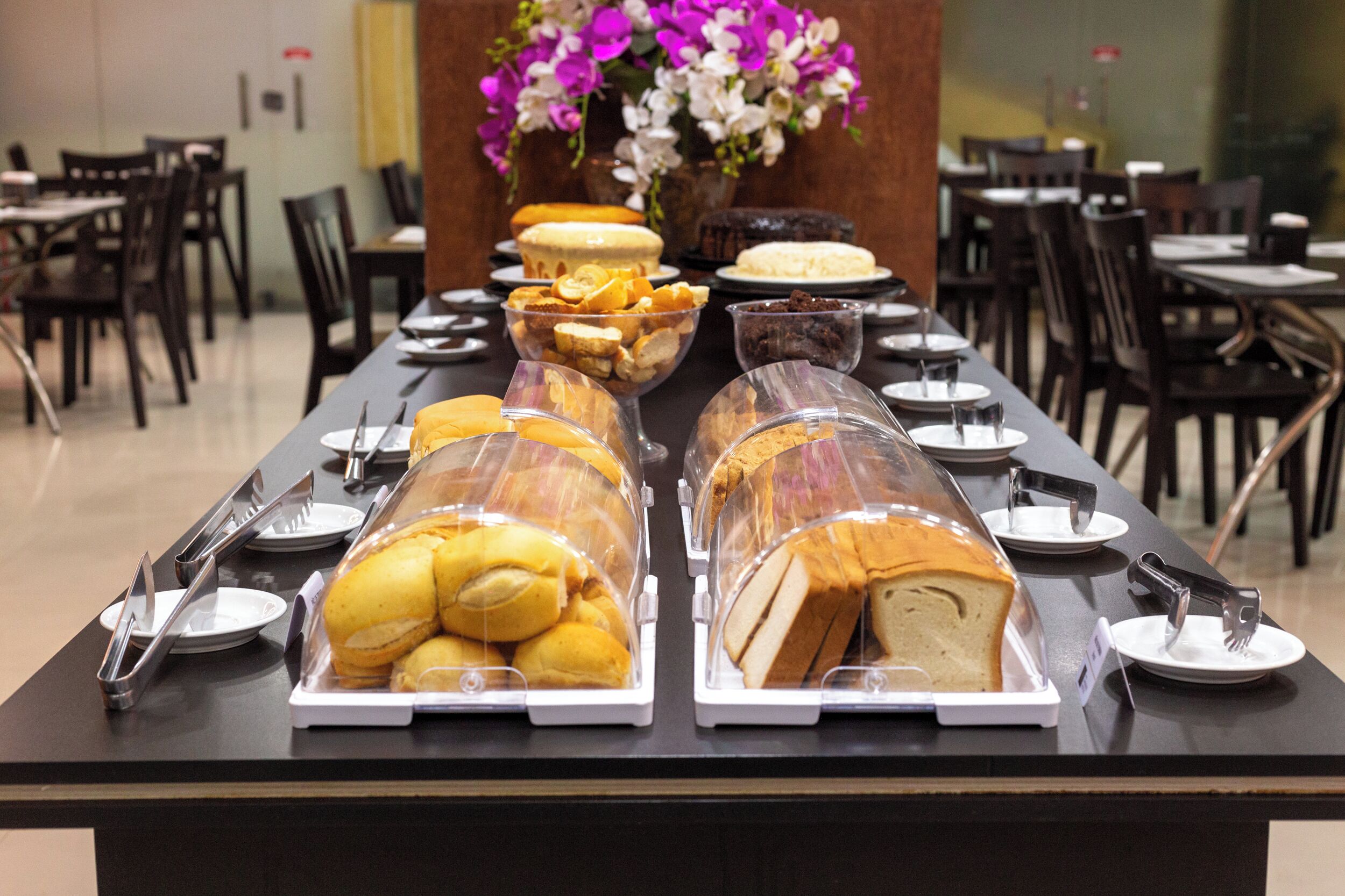 A buffet table with various food items and utensils.
