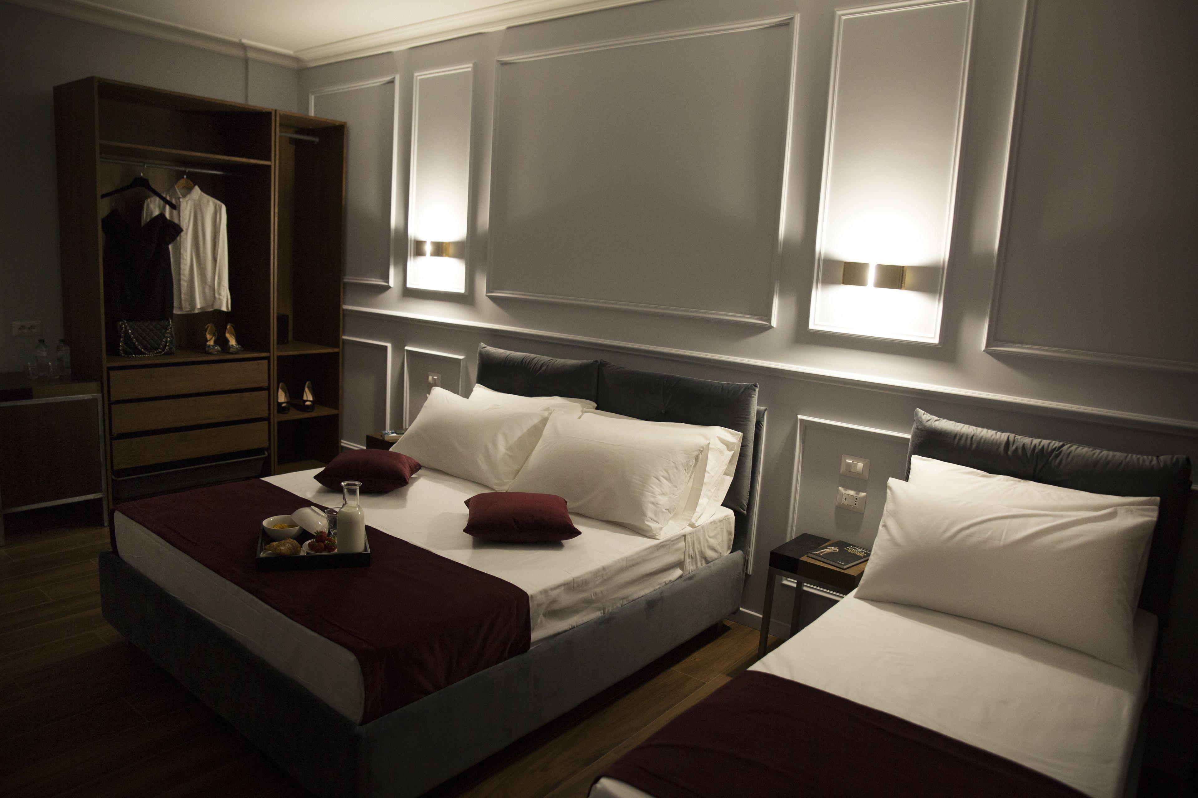 Une chambre d’hôtel avec un grand lit, une armoire et des lampes de chevet.
