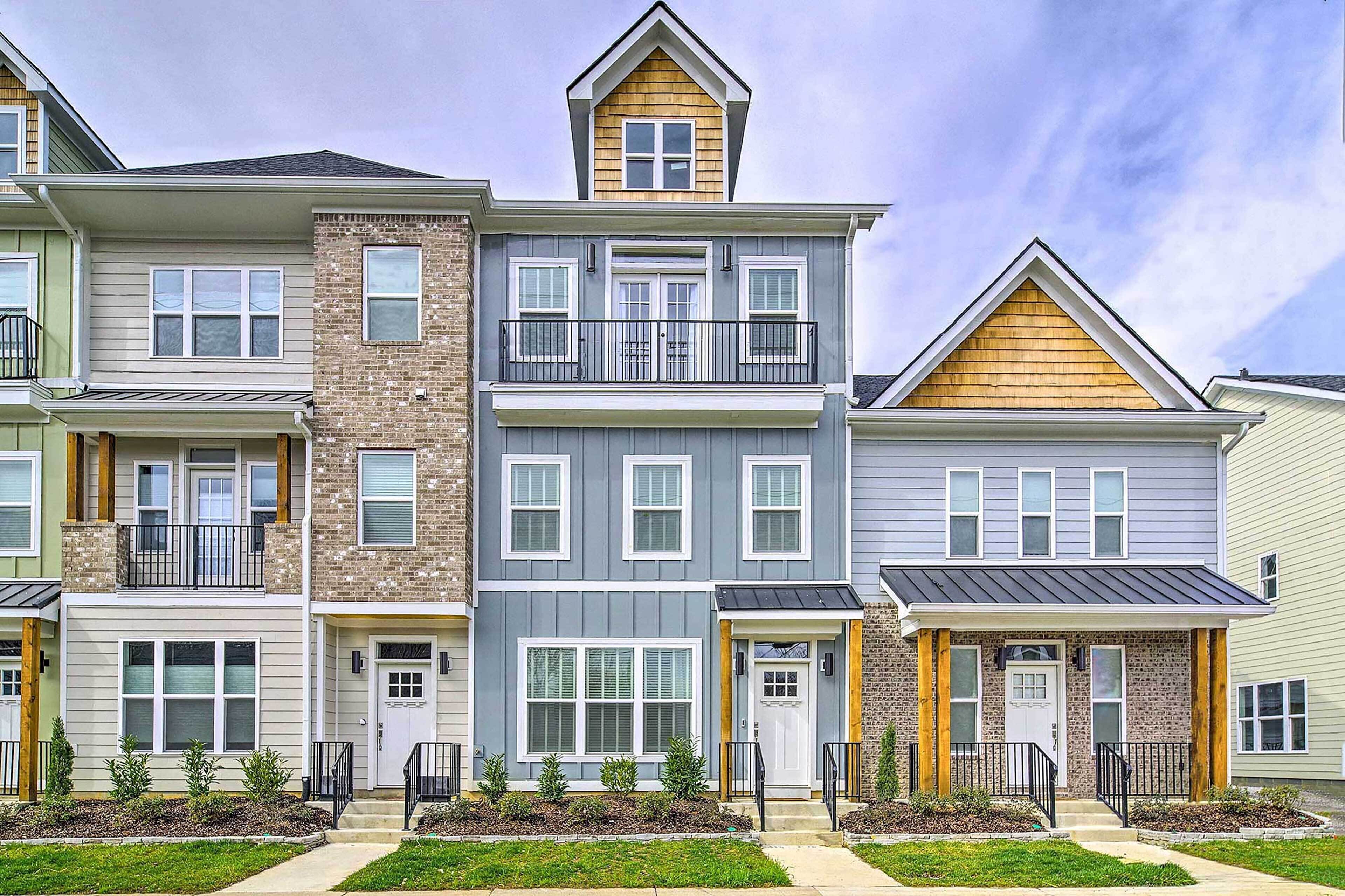 A multi-story residential building with a central entrance, balconies, and a brick facade.