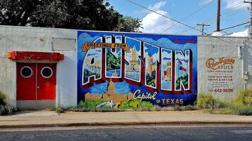 Un mural en una pared con el texto 'Greetings from Austin, Texas' y 'Capitol of Texas'.