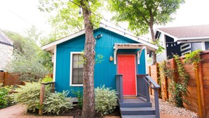 A small, single-story house with a red door and a blue exterior. - Walk to Restaurants & Shopping; 1 mile to SoCo (Austin)
