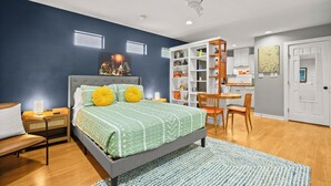 A modern bedroom with a bed, bedside table, and a desk area with a chair. - Walk to Restaurants & Shopping; 1 mile to SoCo (Austin)