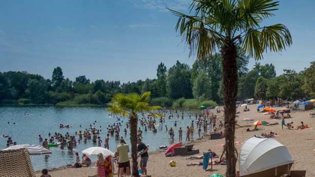 A beach with people swimming and sunbathing, tents, and umbrellas. - The alternative to a hotel: serviced apartment with garden/kitchen/bathroom/hotel service (Bensheim)