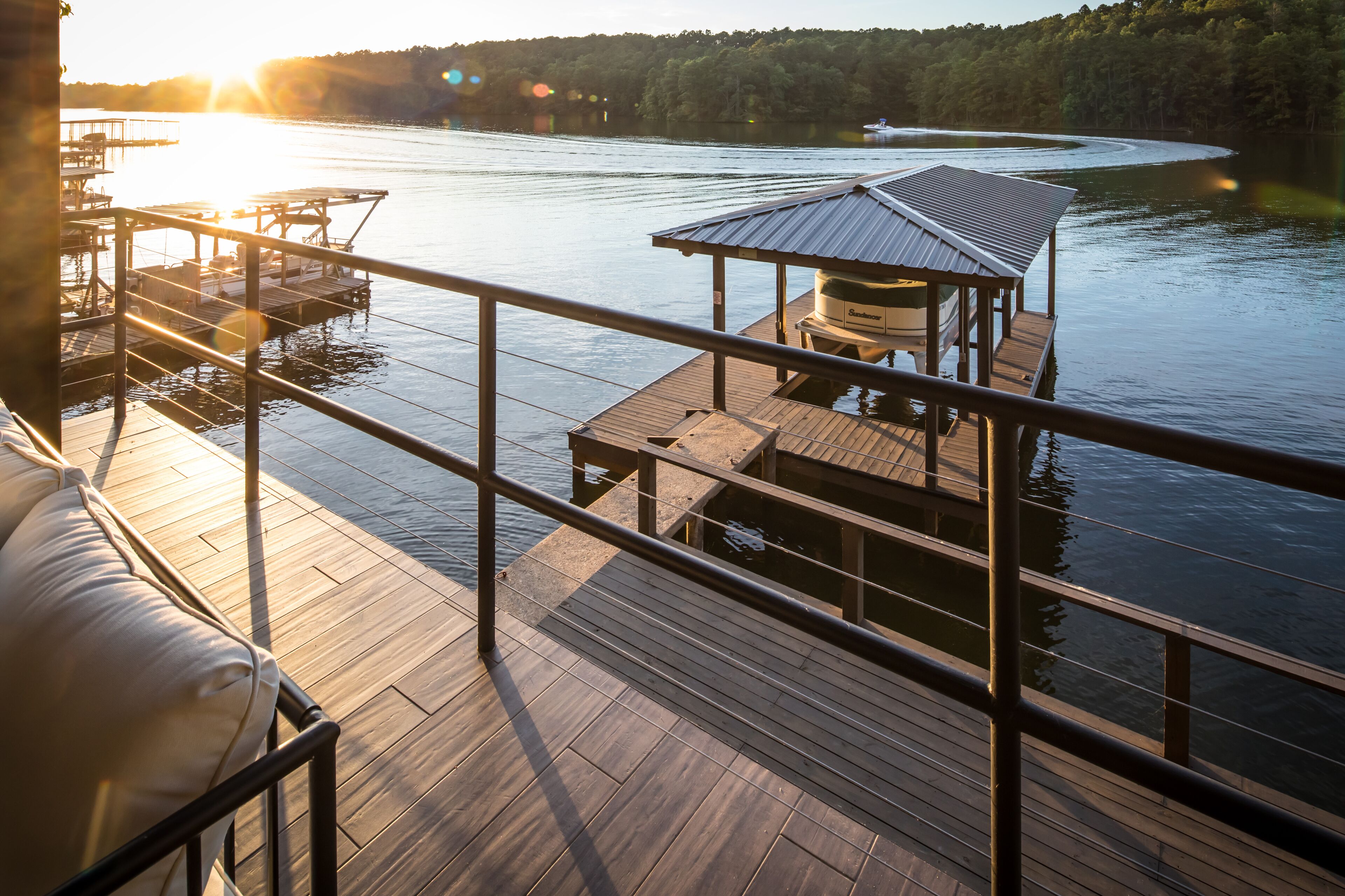 Une terrasse en bois dotée d’un espace salon couvert et d’un quai pour bateaux.