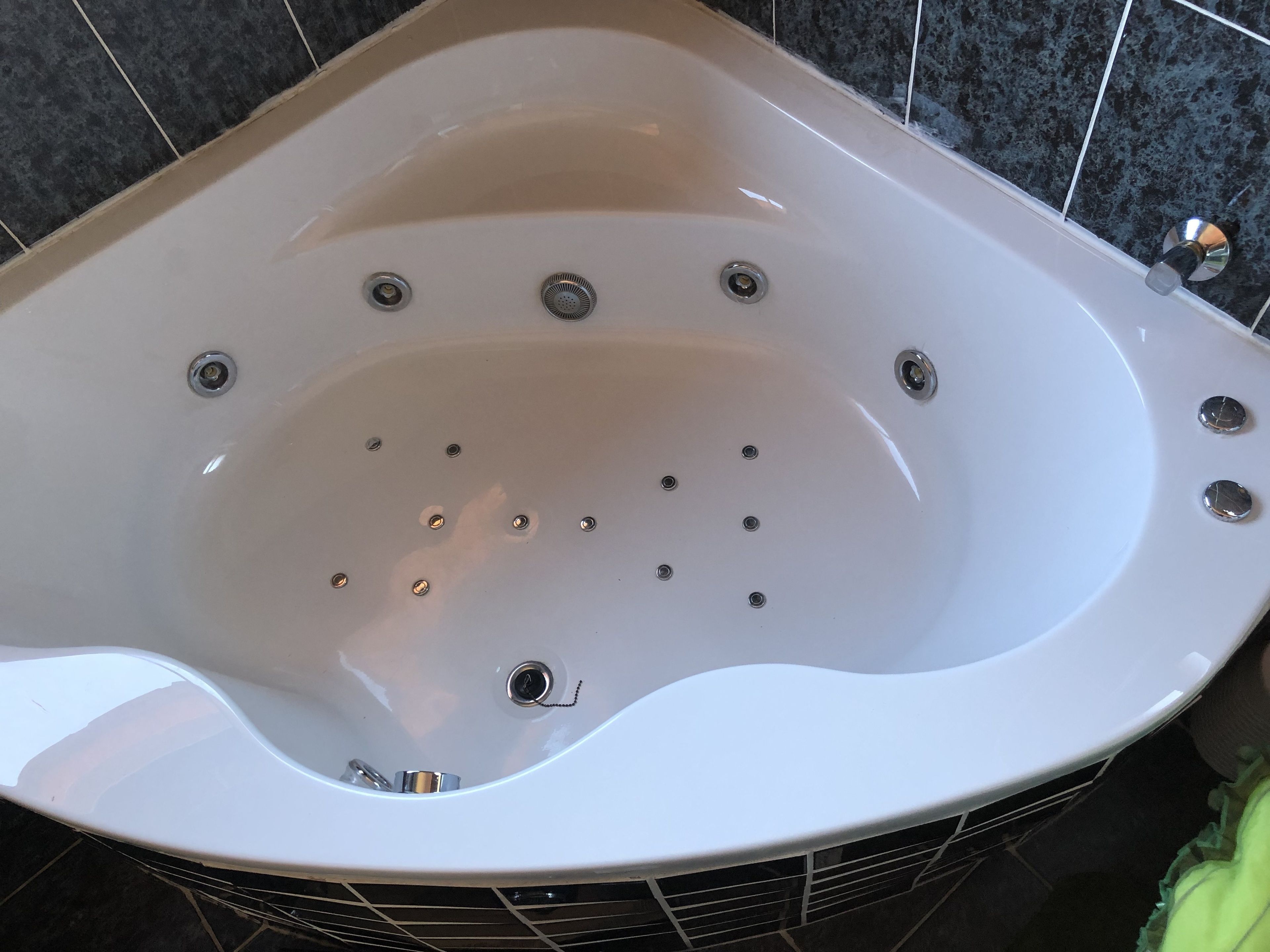 Un baño moderno con una bañera independiente, zona de ducha y suelo de baldosas.