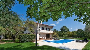 A two-story house with a swimming pool, surrounded by a well-maintained lawn and trees. - ***Apartment with private pool and large garden (Nova Vas)