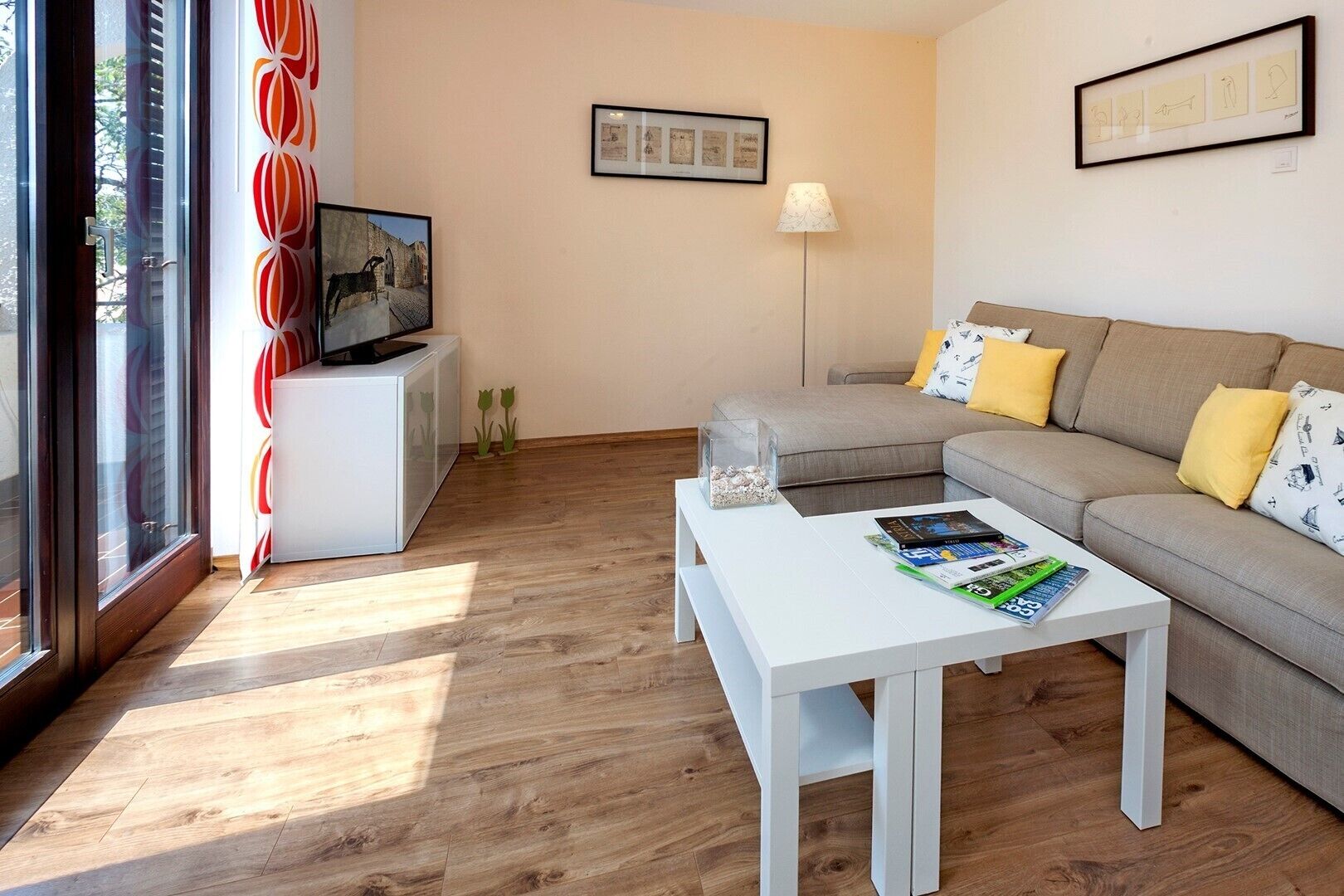 A modern living room with a sofa, a coffee table, and a TV on a stand.