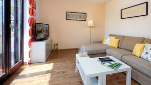 A modern living room with a sofa, a coffee table, and a TV on a stand. - ***Apartment with private pool and large garden (Nova Vas)