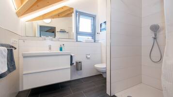 Ein modernes Badezimmer mit Dusche, Toilette und Waschbecken.