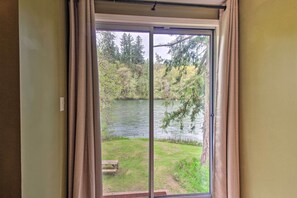 Ein Zimmer mit einer Schiebeglasdoor zum Blick auf einen See.