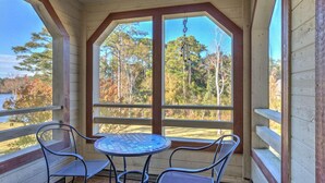 A covered porch with a table and chairs, overlooking a forested area. - Near beach indoor pool hot tub and outdoor pool (Myrtle Beach)