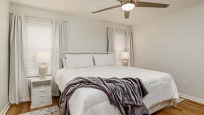 A bedroom with a bed, nightstands, a ceiling fan, and curtains. - Near beach indoor pool hot tub and outdoor pool (Myrtle Beach)