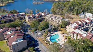 A residential area with multiple apartment buildings, a swimming pool, and a lake in the background. - Near beach indoor pool hot tub and outdoor pool (Myrtle Beach)