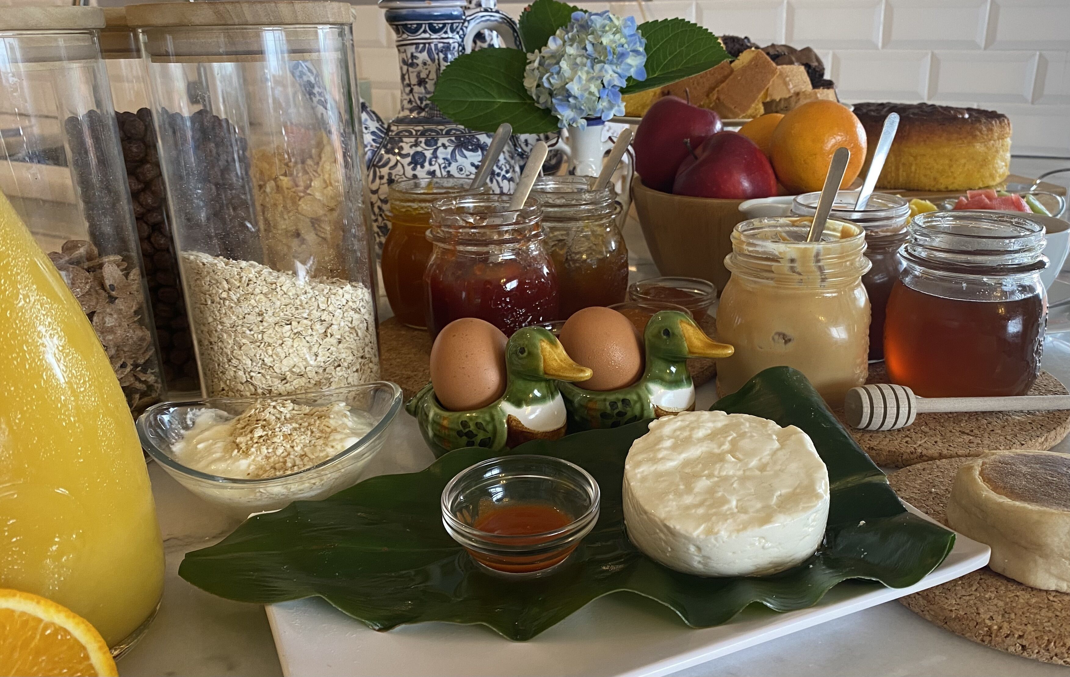 Uma mesa de café da manhã com diversos alimentos e acompanhamentos.