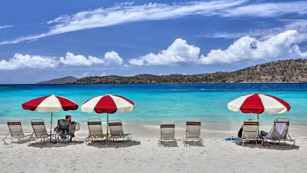A beach with three umbrellas and four lounge chairs. - Saint Thomas Condo w/ Ocean Views, Walk to Beach! (St. Thomas)