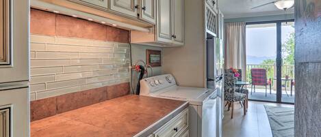 A kitchen with white cabinets, a copper backsplash, and a built-in oven.