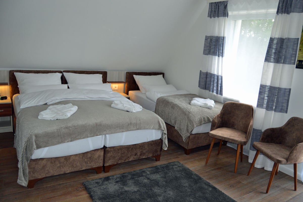 Chambre triple Confort, vue sur le jardin | Literie de qualité, ameublement unique, bureau