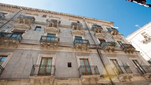 A multi-story building with balconies, large windows, and a classical architectural style. - The Magnificent Apartment (Catania)
