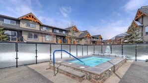 Una zona residencial con piscina, escalones de piedra y casas con balcones de madera.