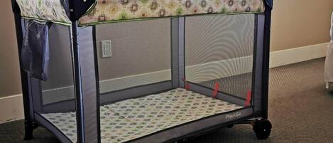 Un corralito plegable con techo de malla y piso estampado, identificado con 'harmony' y 'Play&Go'.