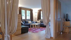 A living room with a sofa, a coffee table, and curtains.