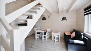 Et moderne interiør med trappe, spiseplads og siddeområde.